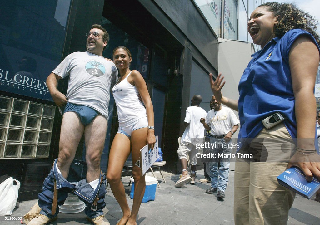 A man strips with a Freshpair.com model in Times Square on the News  Photo - Getty Images
