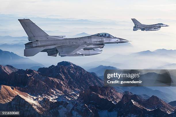 figher aerei volare sopra le montagne - caccia-aereo-militare foto e immagini stock