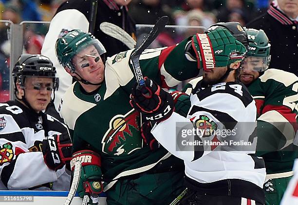 Ryan Carter of the Minnesota Wild and Phillip Danault of the Chicago Blackhawks battle during the first period at the TCF Bank Stadium during the...