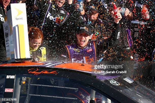 Denny Hamlin, driver of the FedEx Express Toyota, celebrates in Victory Lane after winning the NASCAR Sprint Cup Series DAYTONA 500 at Daytona...