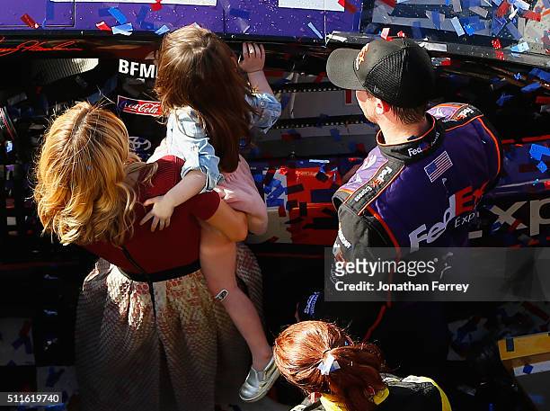 Denny Hamlin, driver of the FedEx Express Toyota, celebrates in Victory Lane with his wife, Jordan Fish, and daughter, Taylor, after winning the...