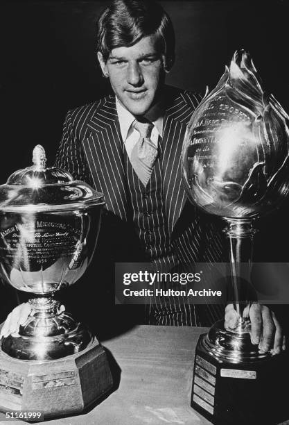 Legendary Canadian hockey player Bobby Orr stands with two of his trophies, the Hart memorial Trophy given to the player in the league considered...