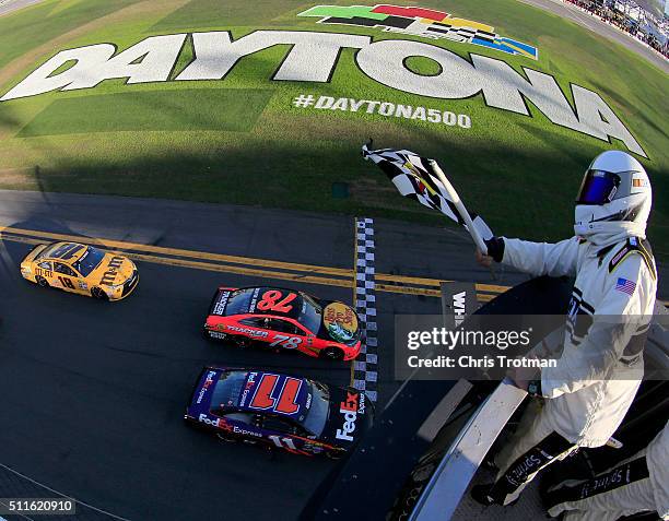 Denny Hamlin, driver of the FedEx Express Toyota, takes the checkered flag ahead of Martin Truex Jr., driver of the Bass Pro Shops/Tracker Boats...