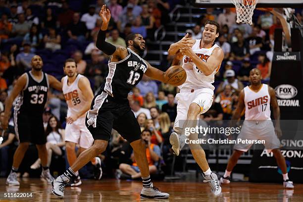 Kris Humphries of the Phoenix Suns and LaMarcus Aldridge of the San Antonio Spurs reach for a loose ball during the first half of the NBA game at...