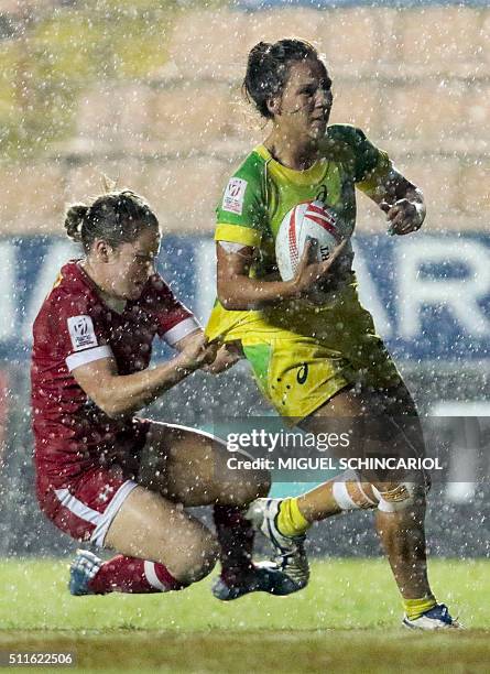 Kayla Moleschi of Canada vies for the ball with Evania Pelite of Australia during their World Rugby Women's Sevens Series match in Barueri, some 30...