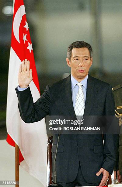 Newly installed Prime Minister Lee Hsien Loong takes his oath of office before Chief Justice Yong Pung How at the Istana presidential palace in...