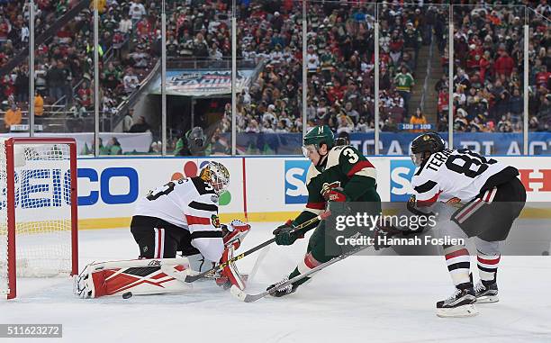 Scott Darling and Teuvo Teravainen of the Chicago Blackhawks defend against Charlie Coyle of the Minnesota Wild during the third period at the TCF...