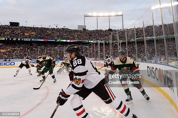 Patrick Kane of the Chicago Blackhawks and Marco Scandella of the Minnesota Wild skate around the boards in the third period of the 2016 Coors Light...