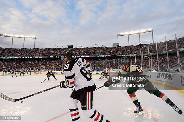 Patrick Kane of the Chicago Blackhawks hits the puck as Marco Scandella of the Minnesota Wild reaches across in the third period of the 2016 Coors...