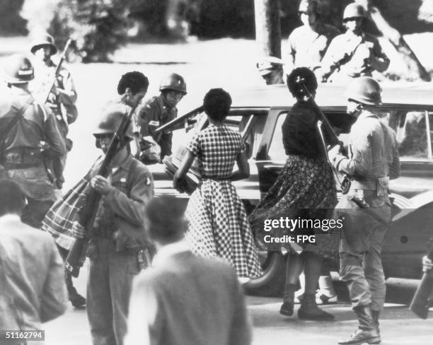 Black students are provided with a military escort when entering and leaving Little Rock Central High School, Arkansas, following the school's...