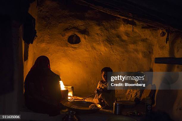 The family of Dhanu Sahariya sit next to a fire at his home in the village of Sakara in Lalitpur district, Madhya Pradesh, India, on Saturday, Feb....