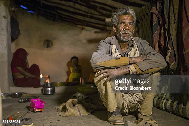 Dharmu Sahariya right, sits with his family at his home in the village of Sakara in Lalitpur district, Madhya Pradesh, India, on Saturday, Feb. 9,...