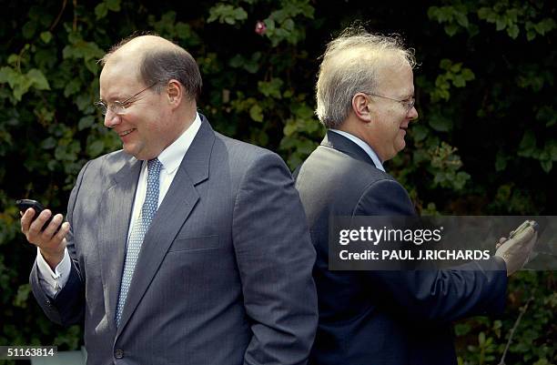 President George W. Bush's Deputy Chief of Staff Joe Hagen and Senior Advisor Karl Rove keep up to date on their Blackberry pagers while waiting in...