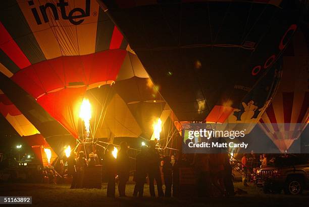 Balloonists gather as part of the night glow balloon display at the "IKEA Bristol International Balloon Fiesta" at the Ashton Court Estate on August...