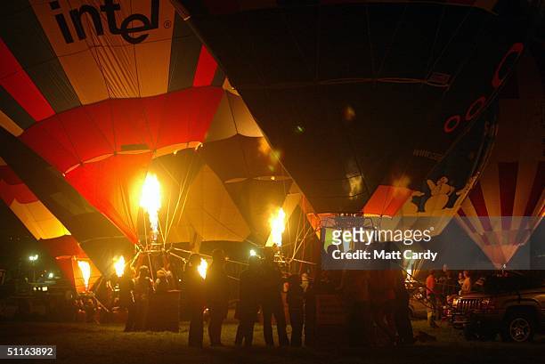 Balloonists gather as part of the night glow balloon display at the "IKEA Bristol International Balloon Fiesta" at the Ashton Court Estate on August...