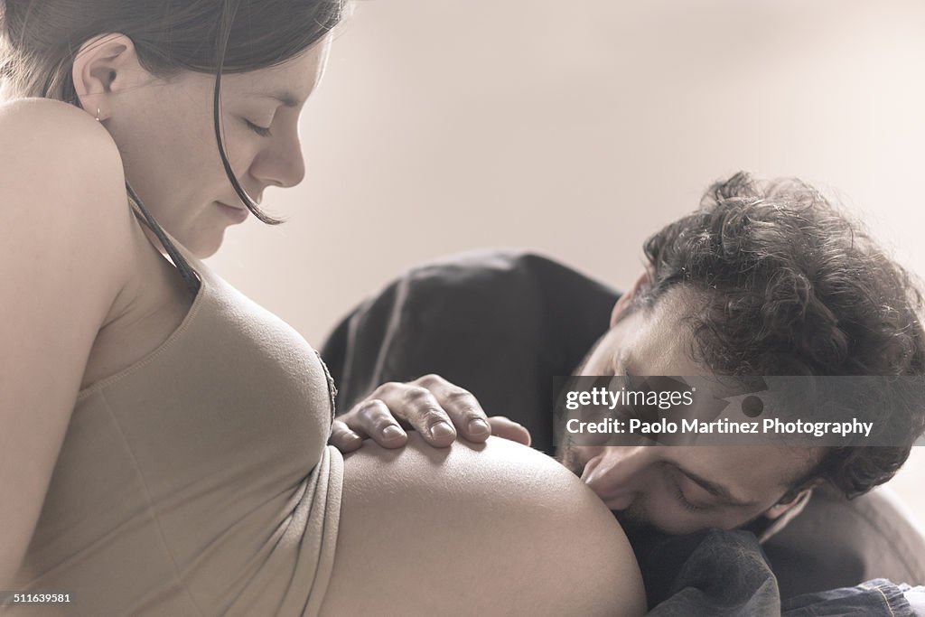 Man kissing stomach of pregnant woman