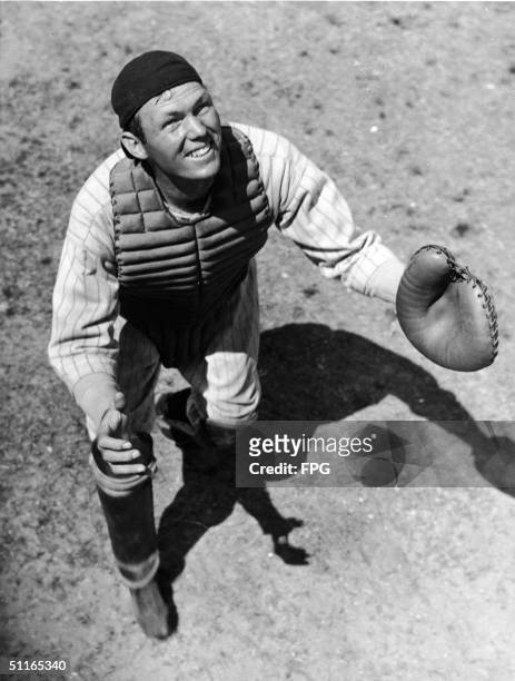 American baseball player Bill Dickey , catcher for the New York Yankees, squints in the sun as he waits for a foul ball during pre-season practice in...