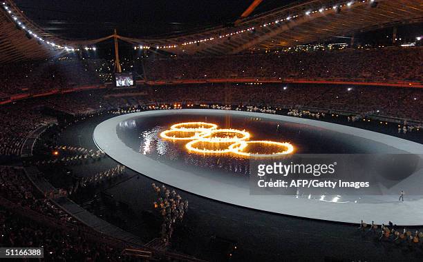 The five Olympic rings are lit with fire in a pool in the Athens Olympic Stadium during the 2004 summer games opening ceremony, 13 August 2004. Some...