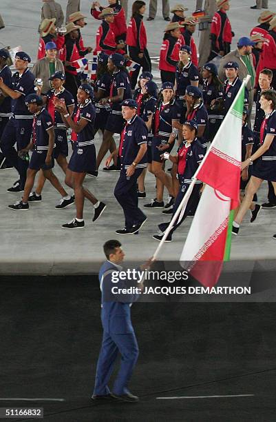 Iran's Arash Miresmaeili leads his country's delegation as the USA delegation walks behind, during the grand opening ceremony of the XXVIII Olympiad...