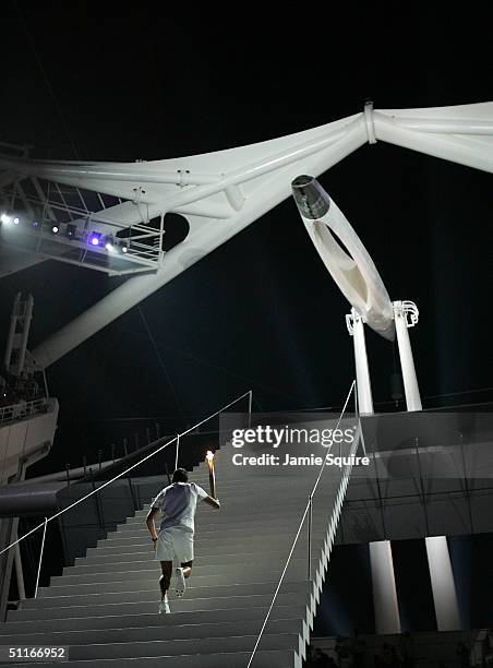 Greek sailor Nicolaos Kakalamanakis runs up stairs with the Olympic torch moments before lighting the Olympic flame during the opening ceremony of...
