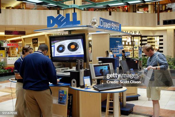 Dell computers sales representatives work with a customer at a Dell Direct Store kiosk in a shopping mall August 13, 2004 in Northbrook, Illinois....