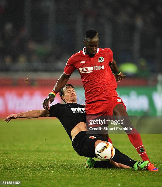 Salif Sané of Hannover is challenged by Markus Feulner of Augsburg during the Bundesliga match between Hannover 96 and FC Augsburg at HDI-Arena on...