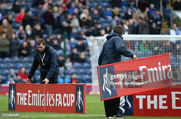 Groundsmen place advertising boards prior to kick off during the Emirates FA Cup fifth round match between Blackburn Rovers and West Ham United at...