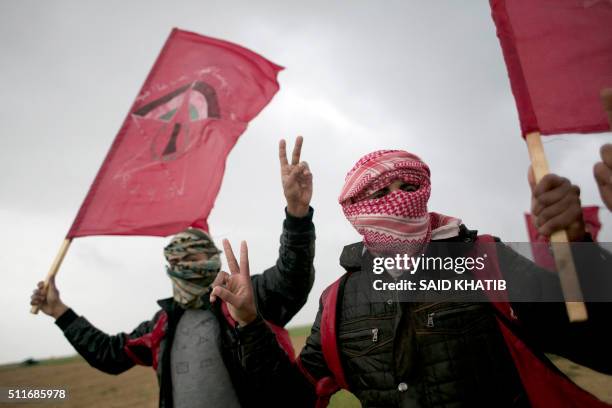 Masked Palestinian supporters of the Democratic Front for the Liberation of Palestine shout slogans and hold flags of the movement during an...