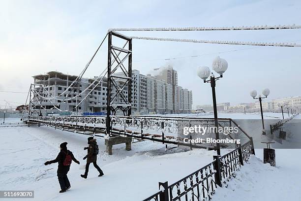 Local youths by pass the bridge as they prepare to cross the frozen city canal on foot in Yakutsk, Sakha Republic, Russia, on Sunday, Feb. 14, 2016....