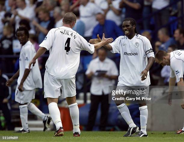 Kevin Nolan congratulates Jay Jay Okocha of Bolton Wanderers after scoring the third goal during the FA Barclays Premiership match between Bolton...
