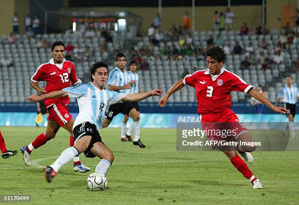 Argentina's Mauro Rosales vies for the ball against Tunisia's Karim Hagui and Anis Ayari , 14 August 2004 in Patras, during the Olympic group C men's...