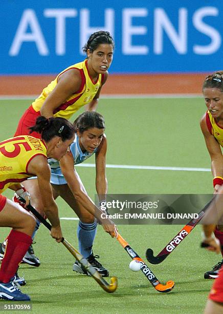 Argentinian hockey player Mariana Alejandra Gonzalez Oliva makes her way through Spanish players during their first round match of women's hockey...