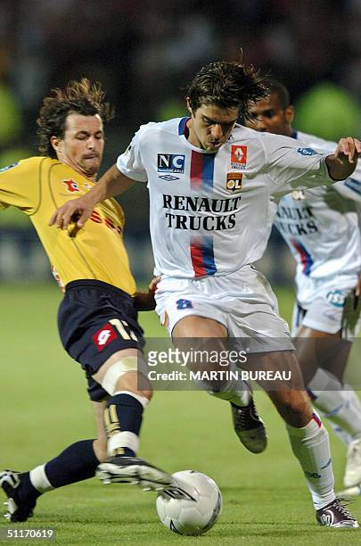 Lyon's Brazilian midfielder Pernambucano Juninho fights for the ball with Sochaux's French midfielder Michael Isabey, 14 August 2004 at the Gerland...