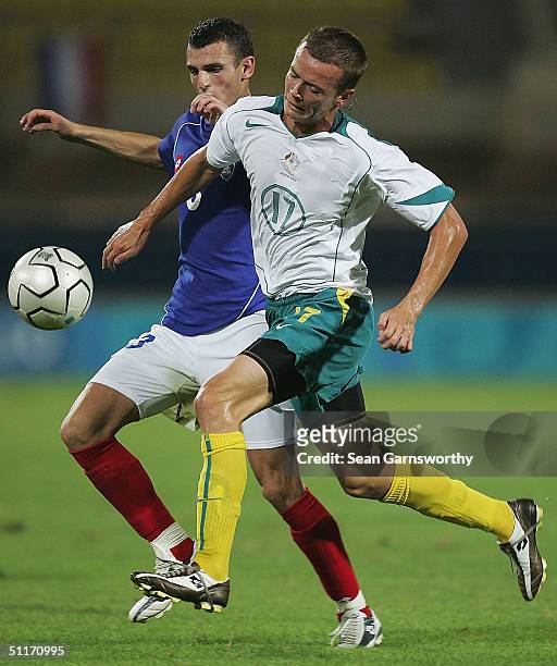 Ryan Griffiths for Australia and Marko Lomic for Serbia in action during the men's football preliminary match between Australia and Serbia and...