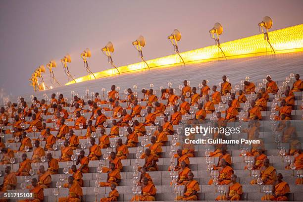 Buddhist monks hold lanterns during a yearly ceremony at Wat Phra Dhammakaya Temple in the north of Bangkok. Thai people celebrate the buddhist...