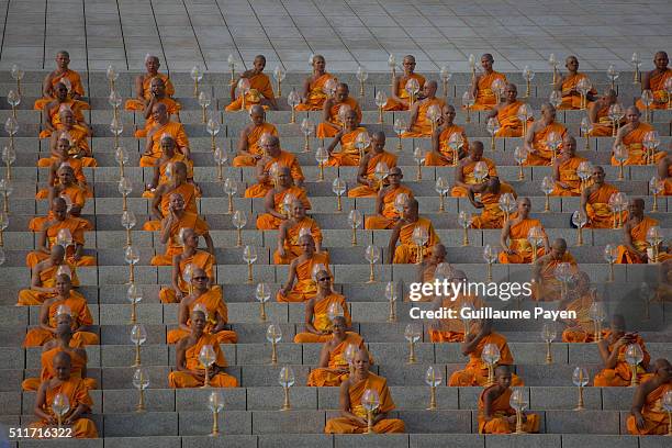 Buddhist monks hold lanterns during a yearly ceremony at Wat Phra Dhammakaya Temple in the north of Bangkok. Thai people celebrate the buddhist...