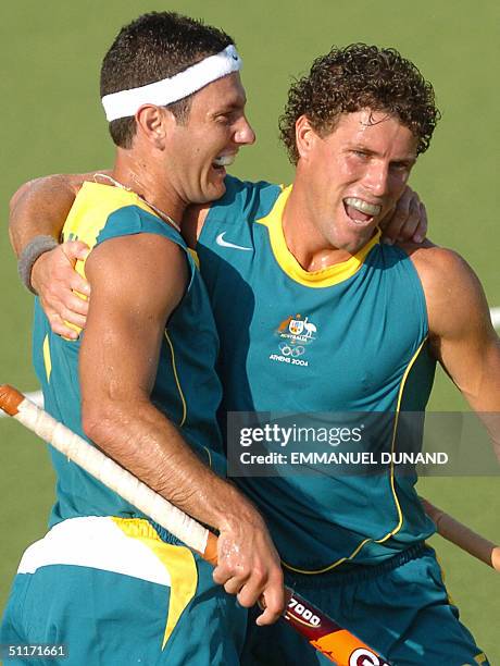 Australian hockey player Jamie Dwyer is congratulated by captain Brent Livermore after scoring against New Zealand during a first round match of the...