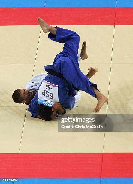 Georgi Georgiev of Bulgaria fights against Oscar Penas of Spain in the men's judo -66 kg class bronze medal contest on August 15, 2004 during the...