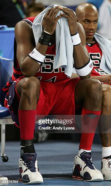 Lamar Odom of the United States covers his head on the bench next to teammate Stephon Marbury in the final moments of their loss to Puerto Rico in...