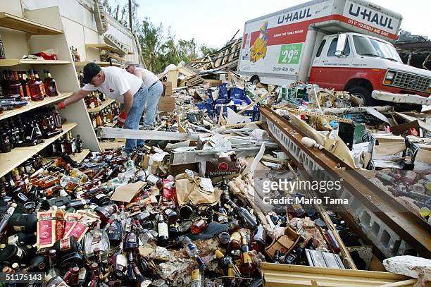 Men attempt to salvage bottles of liquor from a destroyed liquor store August 15, 2004 in Port Charlotte, Florida. Hurricane Charley destroyed many...