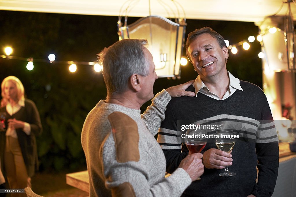 Father and son communicating while enjoying drinks