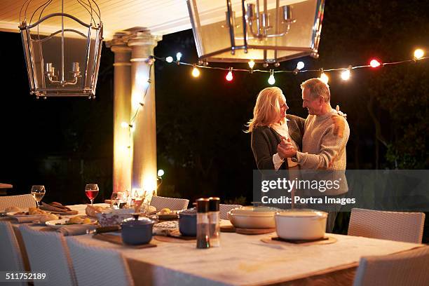 senior couple dancing in front of dining table - senior man dancing on table stock-fotos und bilder