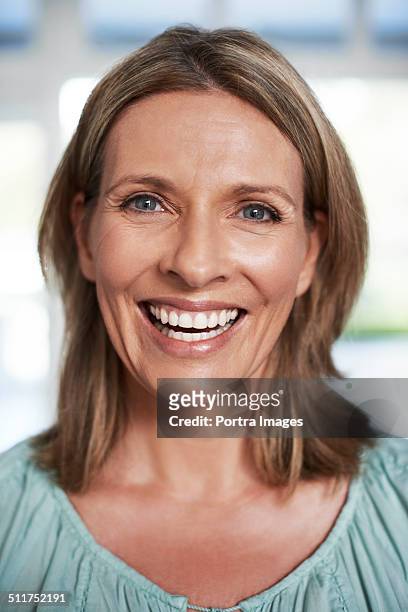 happy mature woman at home - 40 year old woman blonde blue eyes stock pictures, royalty-free photos & images