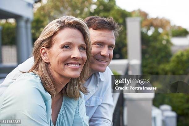 couple looking away in balcony - couple balcony stock pictures, royalty-free photos & images