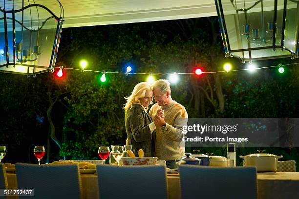 senior couple dancing at table on porch - couple dancing at home stockfoto's en -beelden