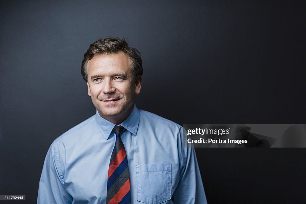 Businessman looking away against blue background