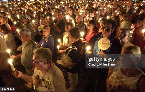 Thousands of Elvis fans hold their candles during the annual candle light vigil August 15, 2004 at Graceland in Memphis, Tennessee. The vigil is the...