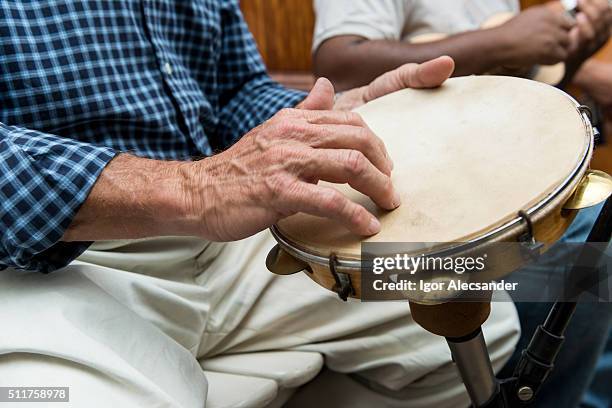 man playing a pandeiro (tambourine) in a chorinho music concert, brazil - pandeiro fotografías e imágenes de stock