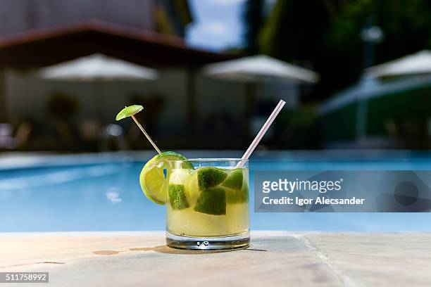 brazilian caipirinha cachaça at the edge of a swimming in a summer sunny day - caipirinha stock pictures, royalty-free photos & images