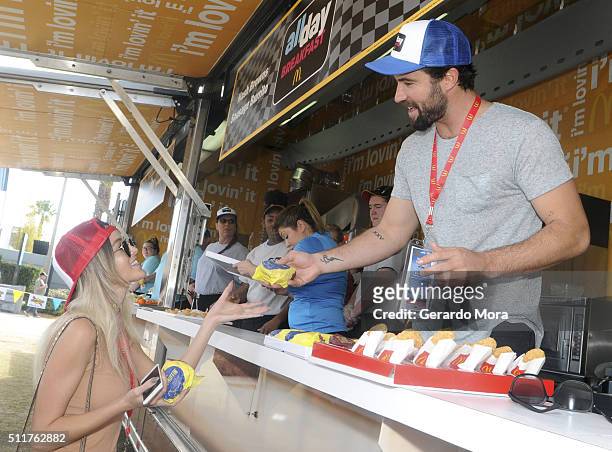 Racing enthusiast, Brody Jenner, serves an Egg McMuffin to girlfriend Kaitlynn Carter from McDonald's McRig during the Daytona 500 at Daytona...